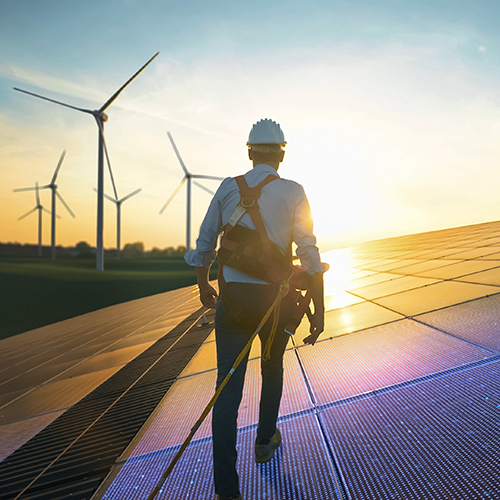 Man performing maintenance on solar panels at dusk