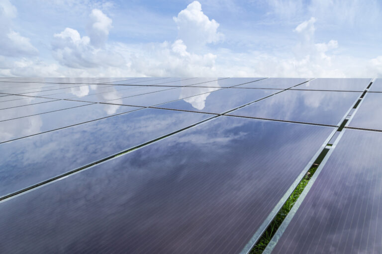 Thin-film solar panels reflecting clouds and sunlight