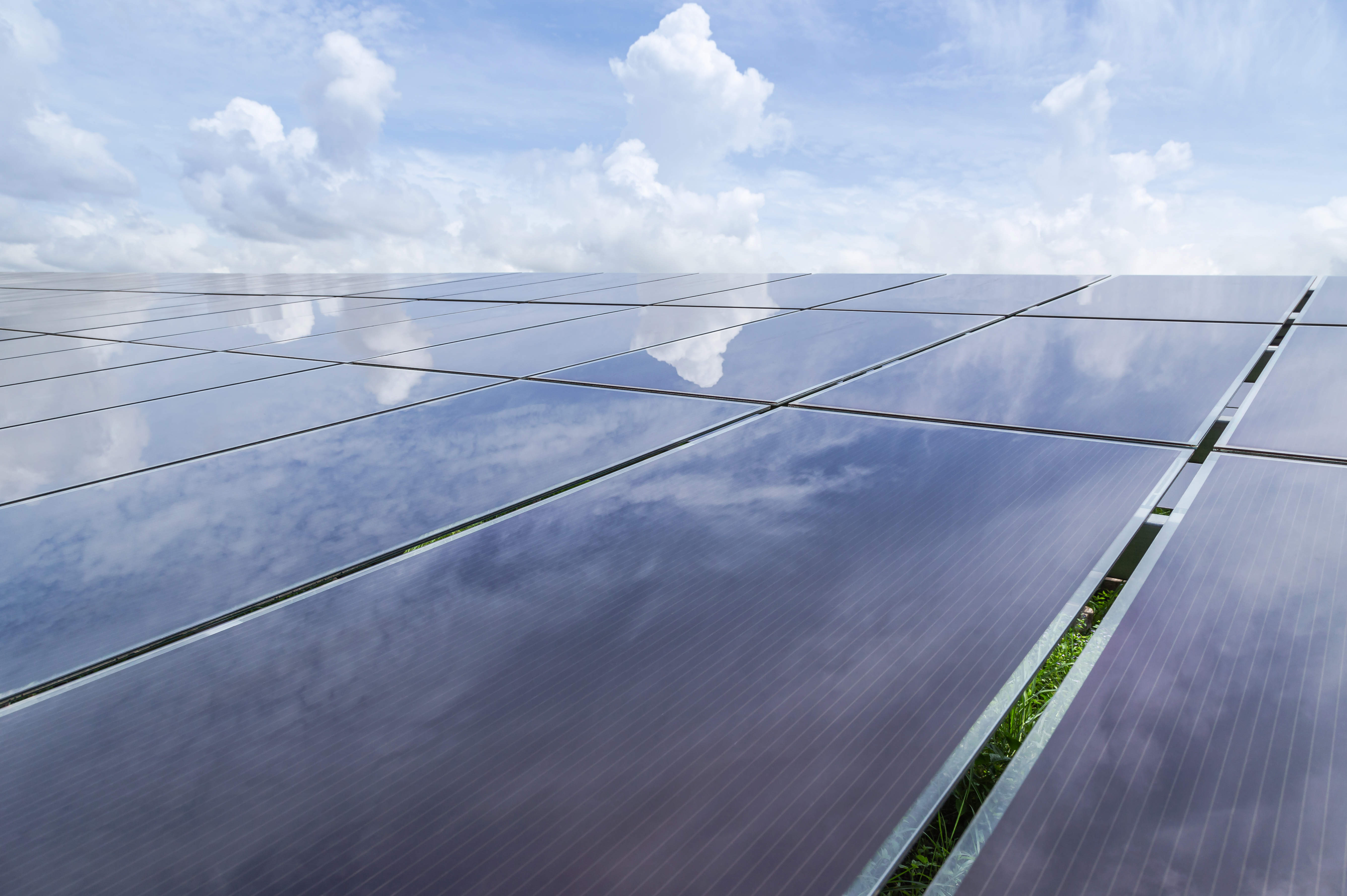 Thin-film solar panels reflecting clouds and sunlight